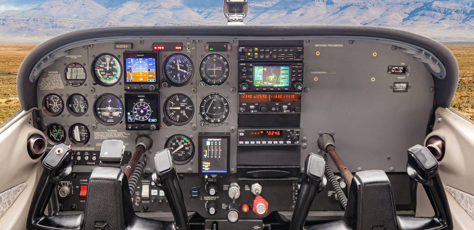Cessna cockpit and instrument panel with Idaho mountains through the windshield at Carmel Aviation in Boise